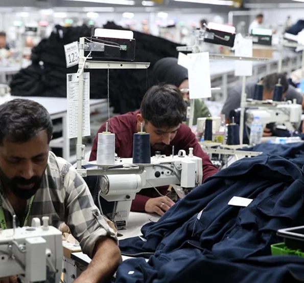 Prague Sports large-scale garment manufacturing facility with rows of industrial sewing machines producing custom sportswear for global export.